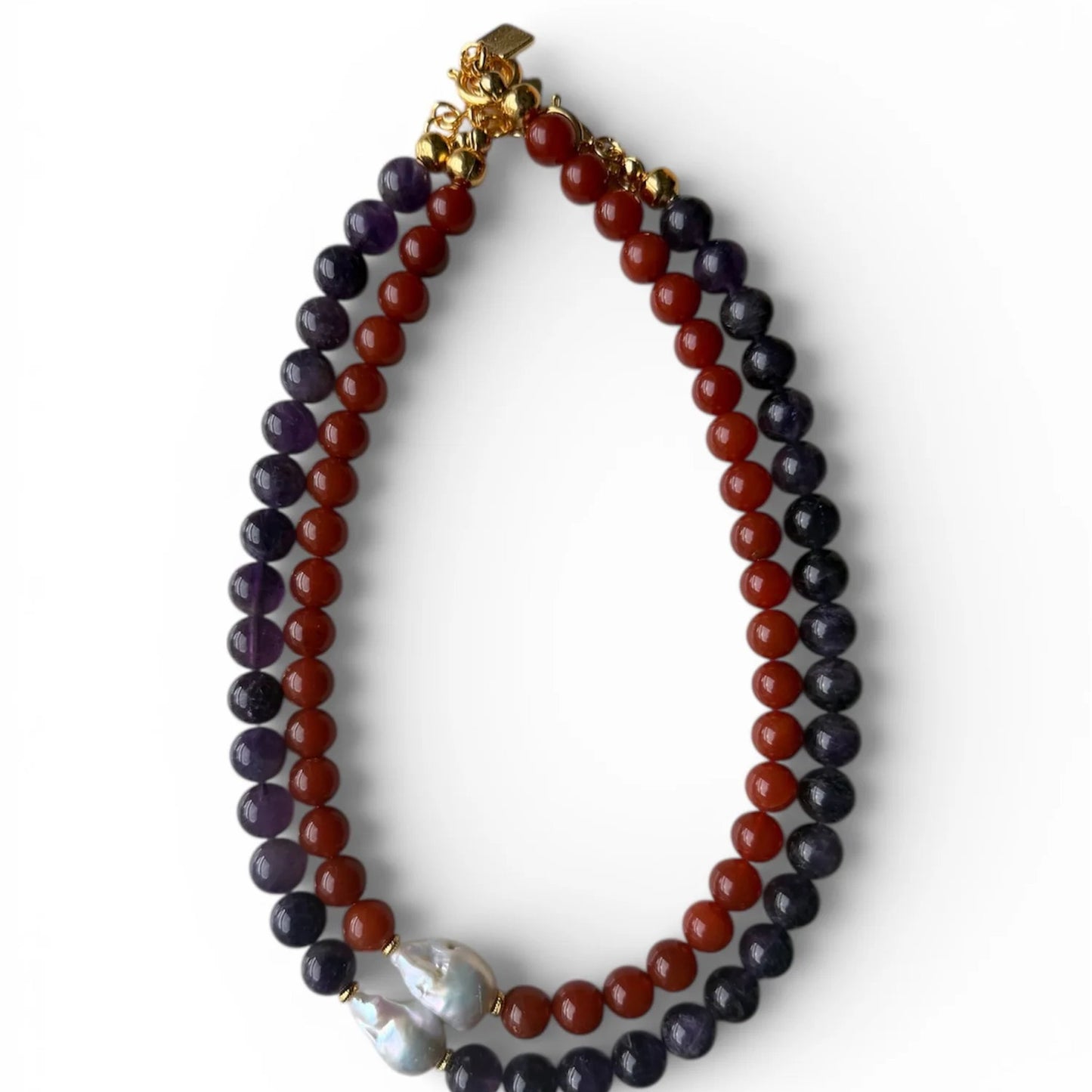 Necklace with red and purple beads and a gold clasp on a white background