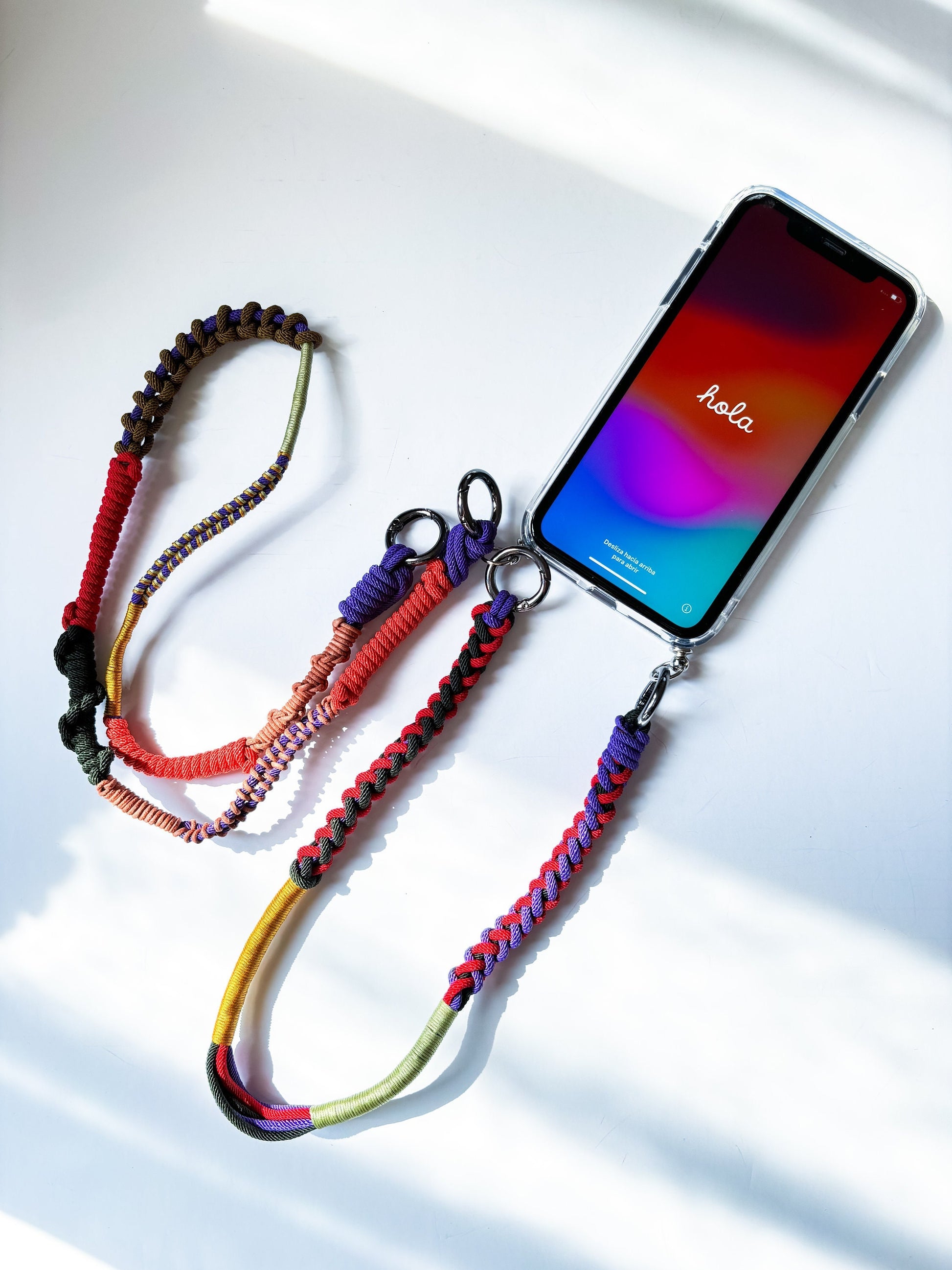 Colorful braided phone lanyard with a smartphone on a white background