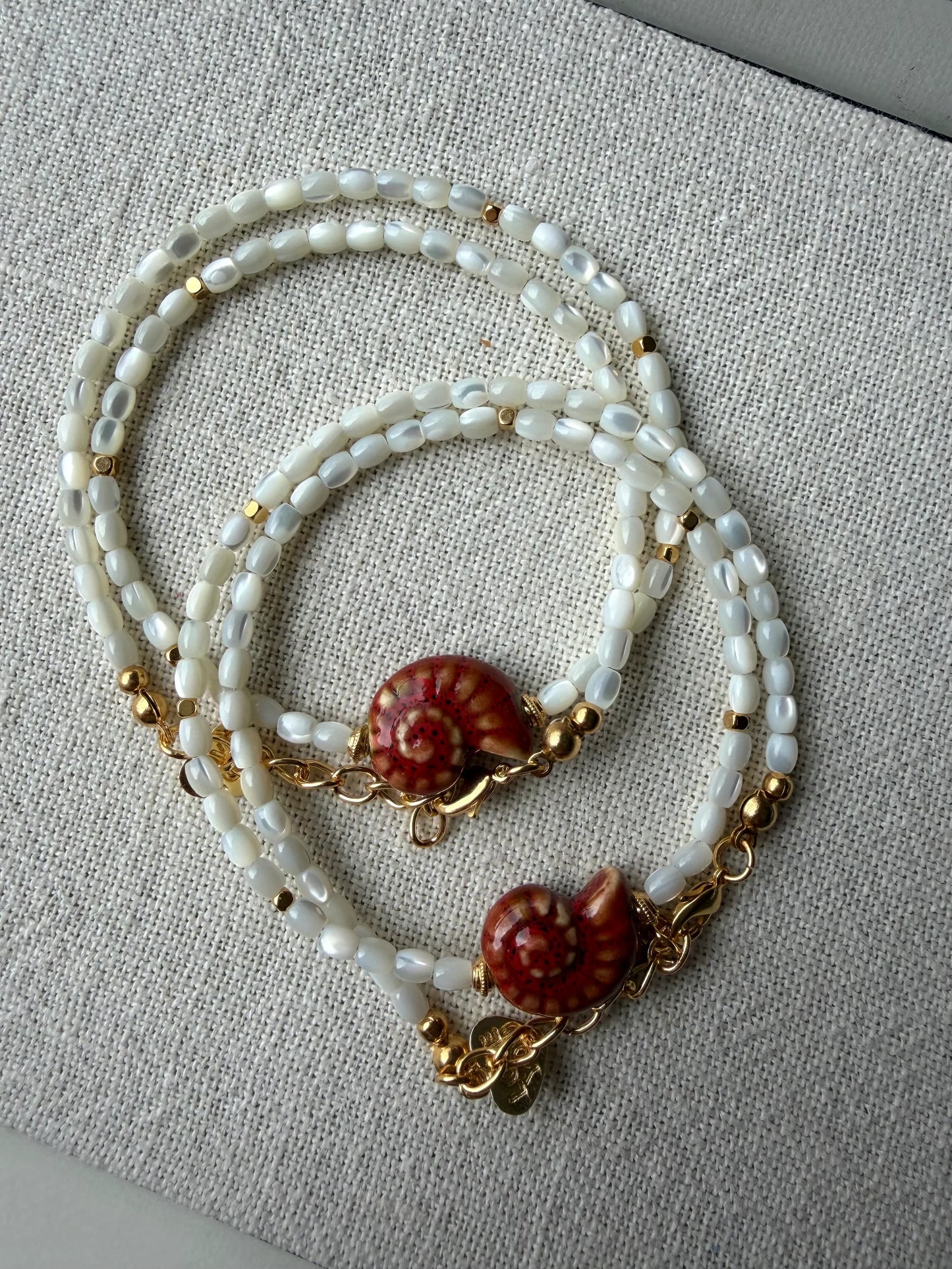 Lunaria Nautilus Necklace displayed on canvas cloth