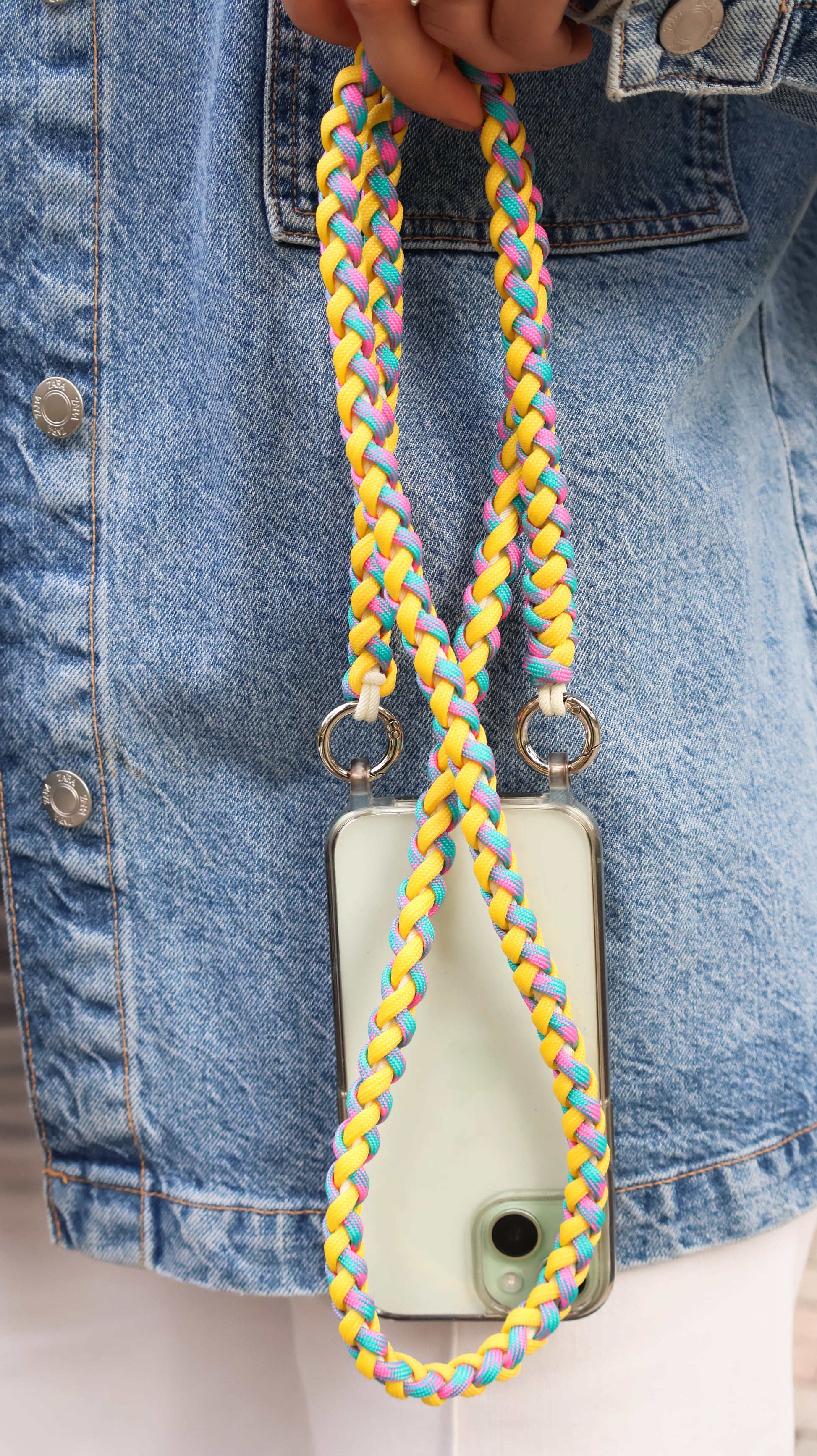 Citrus Twist macrame crossbody strap with a phone case on a denim background