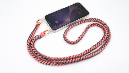 Phone with Coral Drift macrame crossbody strap on a white background