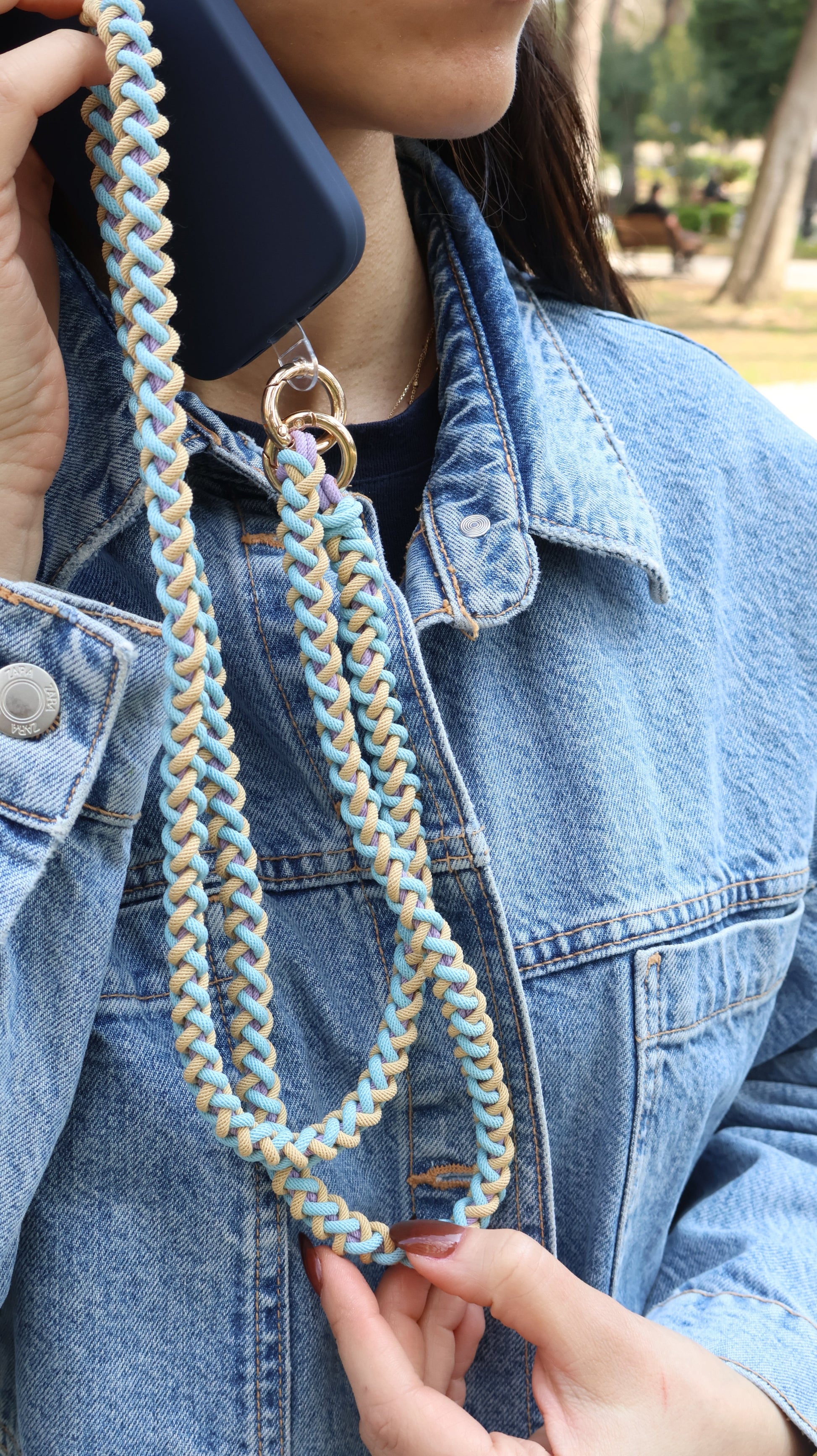 Close-up of a hand holding Laguna Breeze macrame crossbody strap over the shoulder
