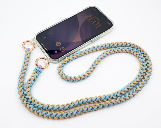 Phone with Laguna Breeze macrame crossbody strap on a white background