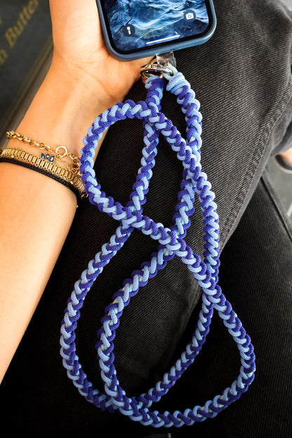 Milan Blue crossbody strap clip detailed held by a person with a phone case attaced