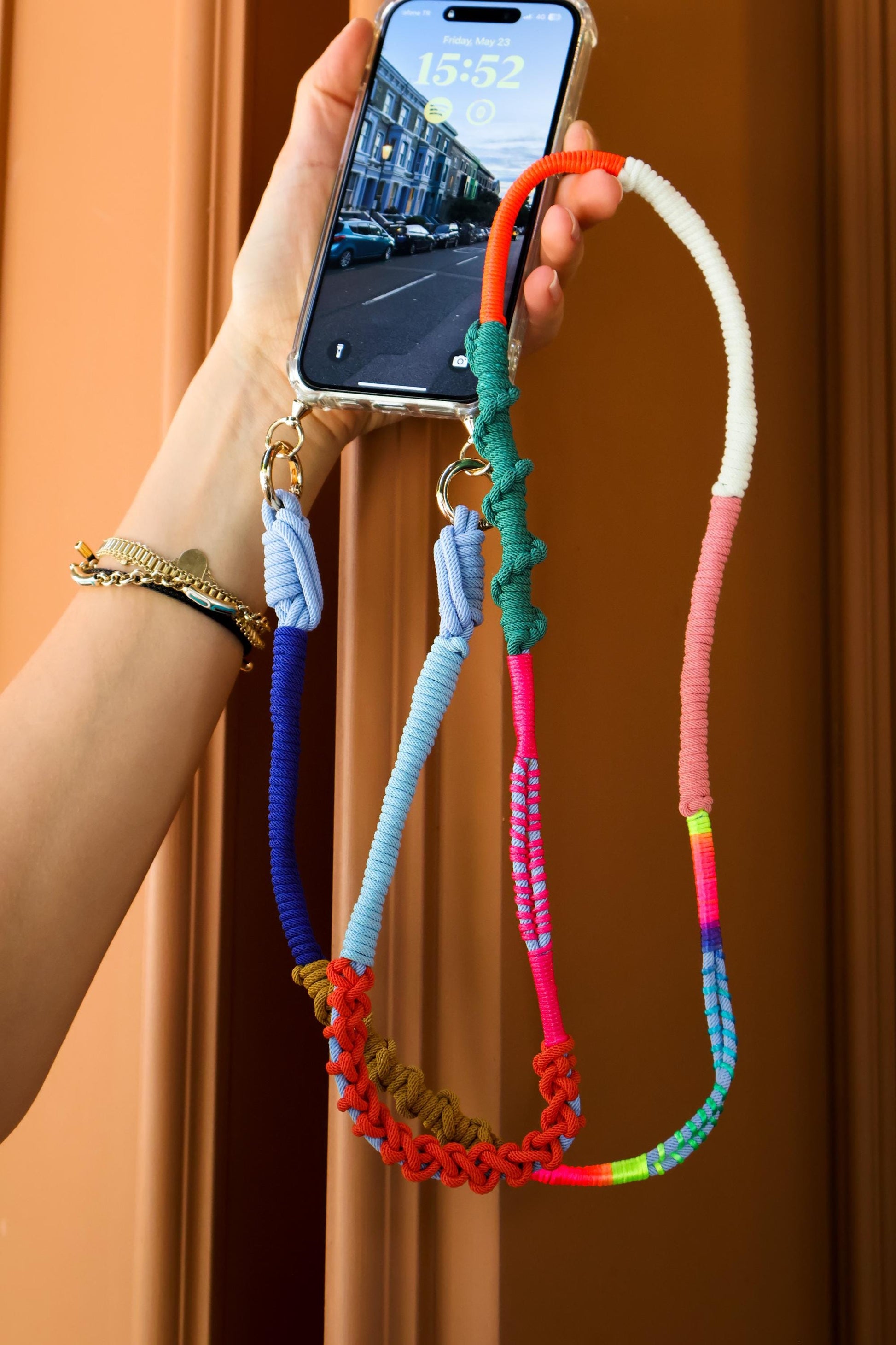Prism Coast macrame crossbody strap held in the air- hand-braided cord, hands-free UAE lifestyle
