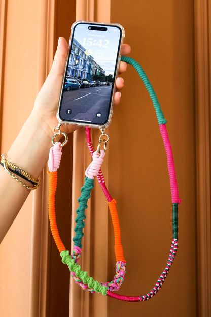 Verdant dune crossbody strap held by a hand with a smartphone displaying a street scene.