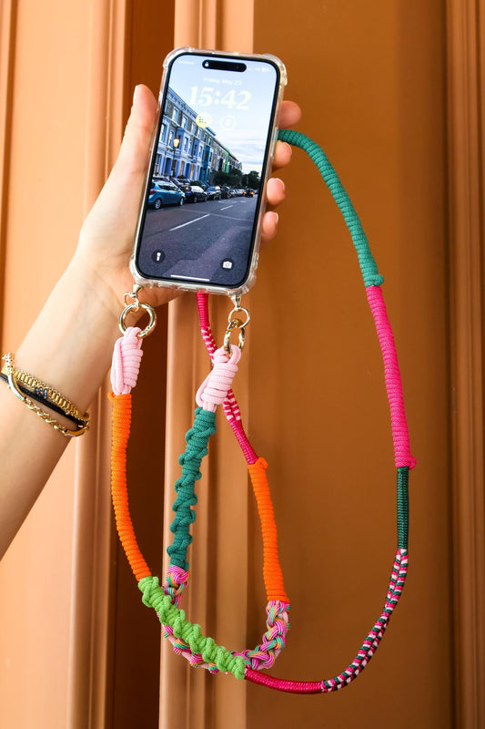 Verdant dune crossbody strap held by a hand with a smartphone displaying a street scene.