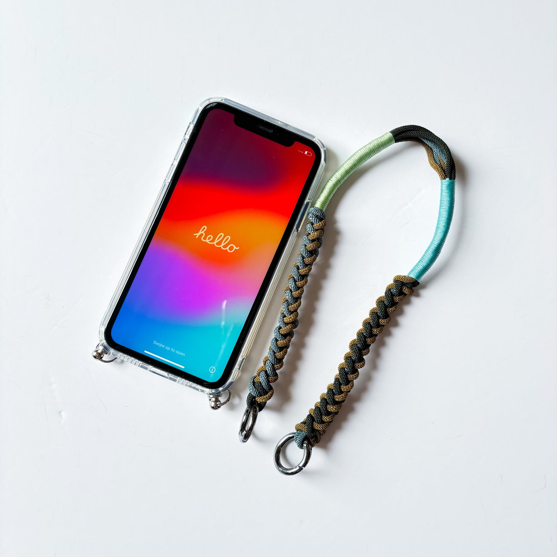 The Wristlet & MagSafe Case Duo - hand-knotted macrame wristlet with a clear strap-ring phone case, flat lay on white