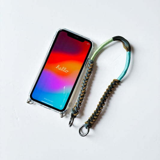 The Wristlet & MagSafe Case Duo - hand-knotted macrame wristlet with a clear strap-ring phone case, flat lay on white